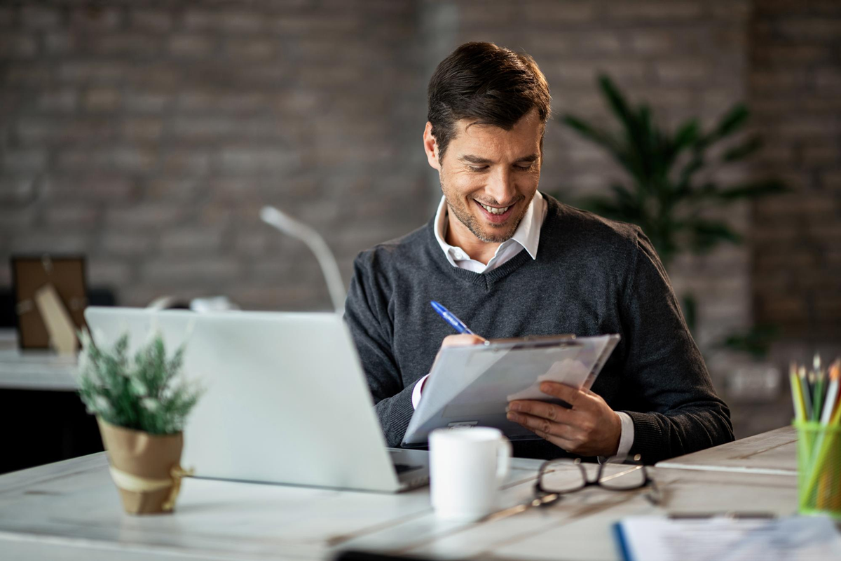 Profissional utilizando notebook e prancheta